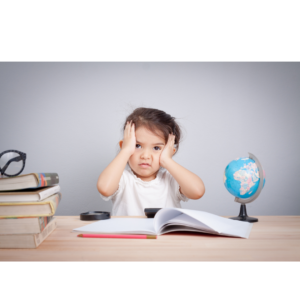 Child sitting in front of a book, looking frustrated with hands on head, illustrating challenges in prolonged speech therapy.